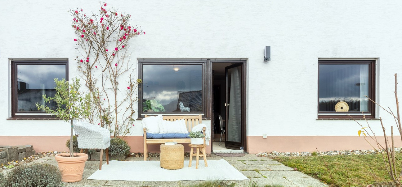 Hausfront mit Terrasse und Sitzbereich